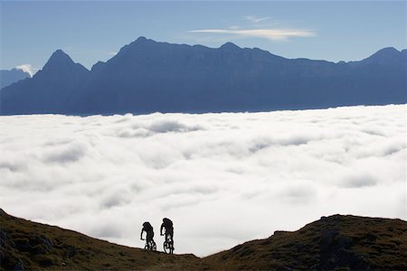 Two mountainbikers in front of a cloud cover Stock Photo - Premium Royalty-Free, Code: 628-02228176