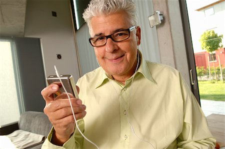 Senior man with headphones and a MP3 Player, close-up Stock Photo - Premium Royalty-Free, Code: 628-02615239