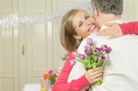 Woman with a bouquet embracing a man Stock Photo - Premium Royalty-Free, Code: 628-02615292