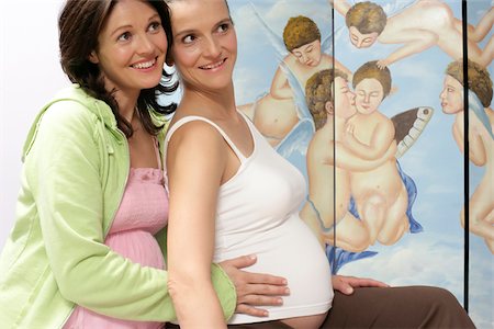 Two pregnant women sitting in front of paravent (folding screen) with angles Stock Photo - Premium Royalty-Free, Code: 628-02615560