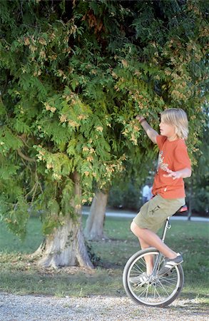 Blonde Boy on an Unicycle - Legerdemain - Youth - Leisure Time - Park Foto de stock - Sin royalties Premium, Código: 628-02615724