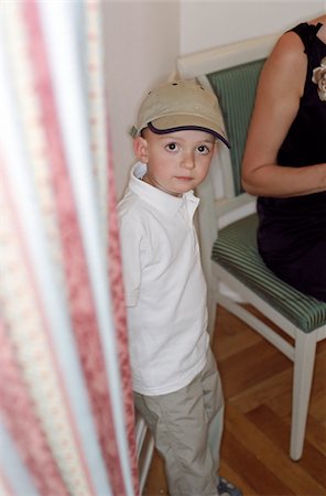 simsearch:628-02954783,k - Petit garçon avec un standing de Cap à côté d'un regard de Rideau - petite enfance- Photographie de stock - Premium Libres de Droits, Code: 628-02615759