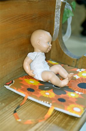 Babydoll on a Pillow with a flowery Pattern on a Bench in a Church - Toy Foto de stock - Sin royalties Premium, Código: 628-02615783