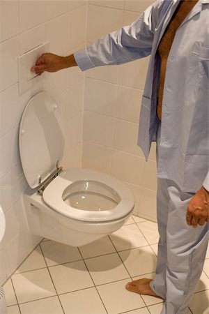 picture men on the toilet - Man flushing toilet, Munich, Bavaria, Germany Stock Photo - Premium Royalty-Free, Code: 628-02615803