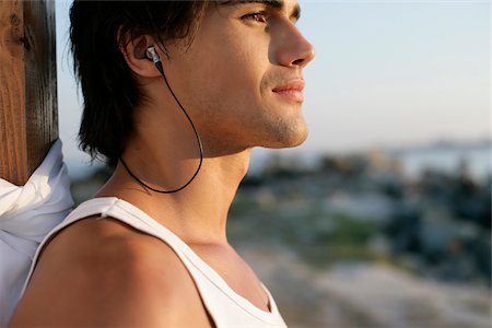 simsearch:628-02615852,k - Man listening to music by earphones Fotografie stock - Premium Royalty-Free, Codice: 628-02615864
