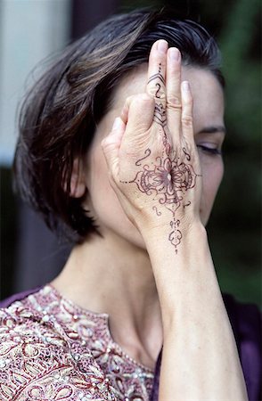 Darkhaired Woman in a Saree holding one with Henna painted Hand over her Eye - Meditation - Tradition Foto de stock - Sin royalties Premium, Código: 628-02954040