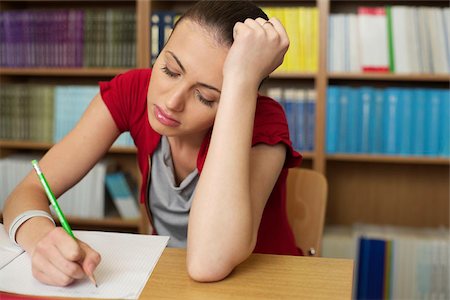 sad person series - Frustrated female student doing her assignment in a library Stock Photo - Premium Royalty-Free, Code: 628-02954253