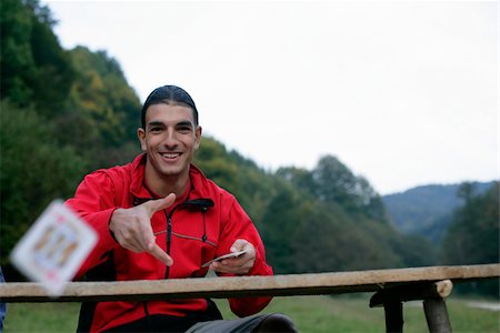 Young man with black hair is throwing a card, selective focus Stock Photo - Premium Royalty-Free, Code: 628-02954330