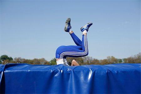 salto em altura - Woman falling on safety mat Foto de stock - Royalty Free Premium, Número: 628-02954423