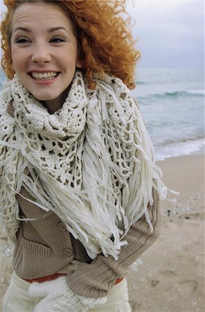 simsearch:628-02954798,k - Young Woman with strawberry-blonde Hair carrying a fringy Scarf around her Neck and is grinning - Fun - Happiness - Beach Fotografie stock - Premium Royalty-Free, Codice: 628-02954631