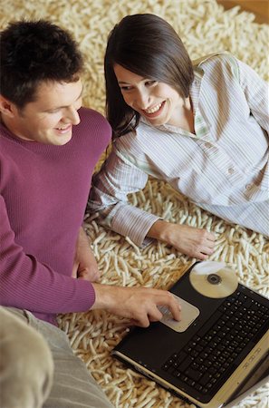 simsearch:628-02615784,k - Woman lying next to a Man with Laptop on a Carpet - Communication - Technology - Living Room Stock Photo - Premium Royalty-Free, Code: 628-02954771
