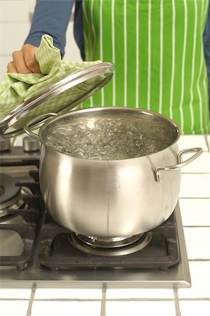 pots on a stove - Woman cooking at gas stove Stock Photo - Premium Royalty-Free, Code: 628-02953536