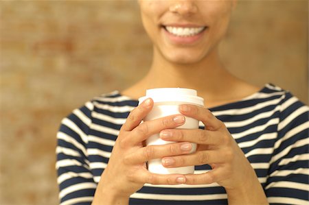 Jeune femme tenant une tasse en plastique souriante Photographie de stock - Premium Libres de Droits, Code: 628-02953538