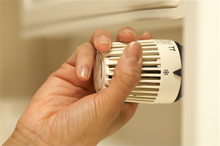 person and thermostat - Woman turning off heater Stock Photo - Premium Royalty-Free, Code: 628-02953554