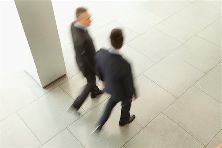 Two businessmen walking in lobby, Munich, Bavaria, Germany Stock Photo - Premium Royalty-Free, Code: 628-02953597