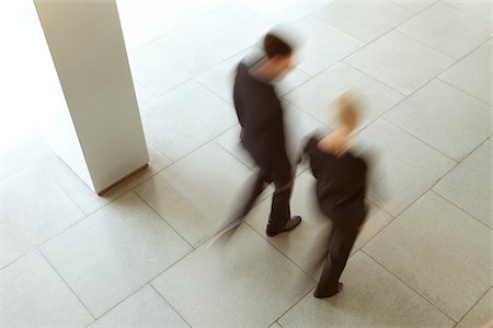 debates - Businessman and businesswoman walking in lobby, Munich, Bavaria, Germany Stock Photo - Premium Royalty-Free, Code: 628-02953644