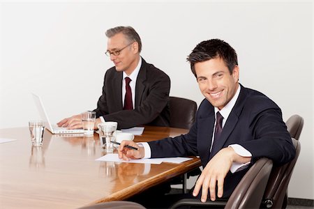 Two businessmen talking in conference room, Munich, Bavaria, Germany Stock Photo - Premium Royalty-Free, Code: 628-02953643