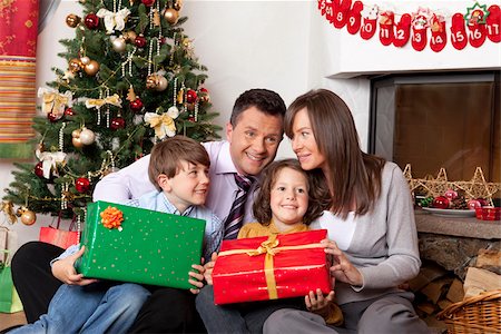 simsearch:628-03058864,k - Family with two children at Christmas tree Foto de stock - Royalty Free Premium, Número: 628-02953655