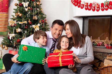 female holding christmas present - Family with two children at Christmas tree Stock Photo - Premium Royalty-Free, Code: 628-02953655