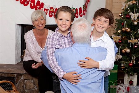 simsearch:628-03058864,k - Grandfather carrying grandchildren at Christmas tree Foto de stock - Royalty Free Premium, Número: 628-02953665