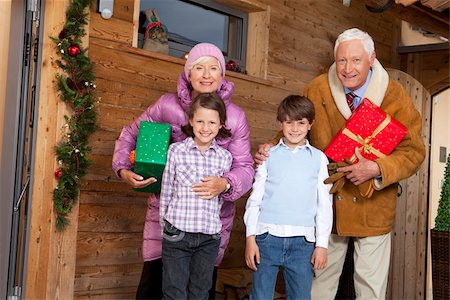 Großeltern mit Enkelkindern halten Weihnachten präsentiert auf Holzhaus Stockbilder - Premium RF Lizenzfrei, Bildnummer: 628-02953670