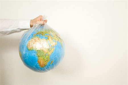 Man holding garbage bag with globe, Germany Stock Photo - Premium Royalty-Free, Code: 628-02953744