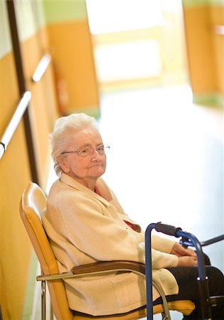 Haute femme assise dans le couloir en maison de retraite Photographie de stock - Premium Libres de Droits, Code: 628-02953798