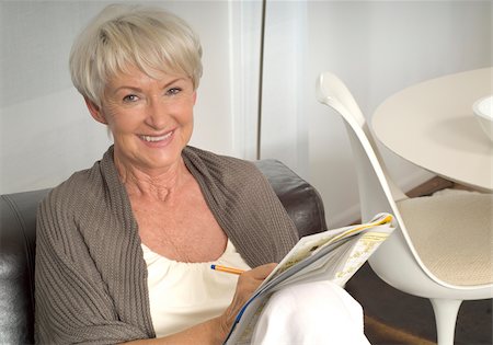 senior emotion - Senior woman sitting with crossword puzzle on sofa Stock Photo - Premium Royalty-Free, Code: 628-02953825