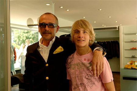 simsearch:628-03201079,k - Well-dressed shopkeeper has his arm around a young blond man, selective focus Stock Photo - Premium Royalty-Free, Code: 628-03201069