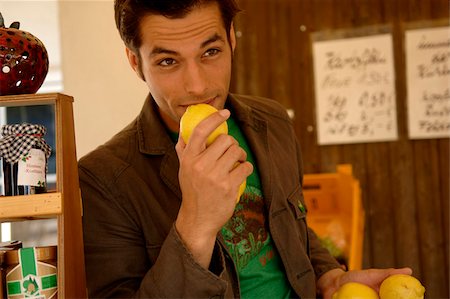 simsearch:628-03201079,k - Young man with black hair holding some lemons in his hands, selective focus Stock Photo - Premium Royalty-Free, Code: 628-03201063