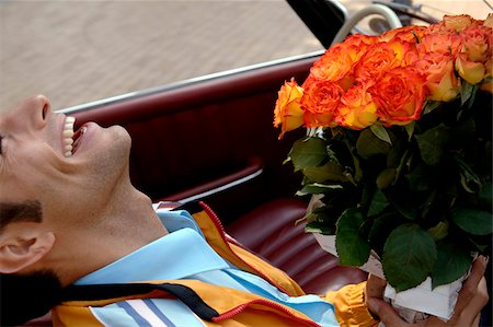 simsearch:628-03201079,k - Jeune homme aux cheveux noirs assis dans une voiture avec un bouquet de roses, gros plan Photographie de stock - Premium Libres de Droits, Code: 628-03201070
