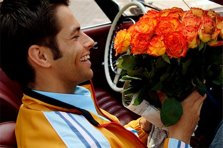 simsearch:628-03201079,k - Young man with black hair sitting in a car with a bunch of roses, close-up Stock Photo - Premium Royalty-Free, Code: 628-03201111
