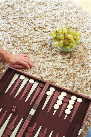 Backgammon Board (cropped) and Bowl with Grapes laying on a Carpet Stock Photo - Premium Royalty-Free, Code: 628-03201291