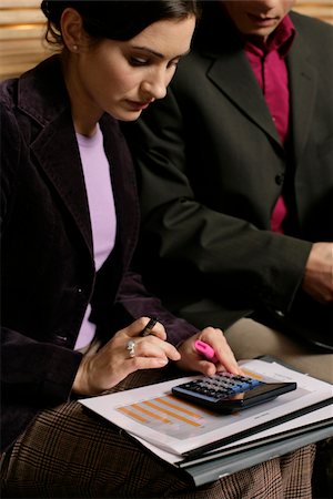 Businesswoman using a pocket calculator Stock Photo - Premium Royalty-Free, Code: 628-03201380