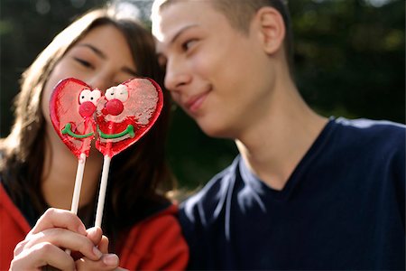 Teenage couple holding heart-shaped lollypops together Stock Photo - Premium Royalty-Free, Code: 628-03201405