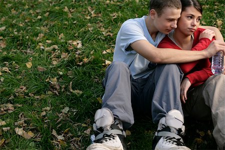 Teenage couple sitting on grass and embracing Stock Photo - Premium Royalty-Free, Code: 628-03201401