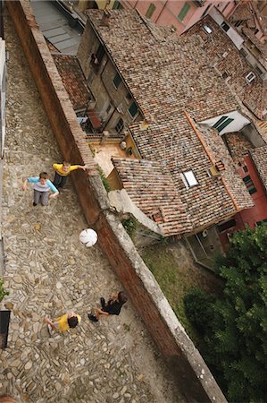 friends playing football - Boys Playing Soccer In Narrow Street Foto de stock - Sin royalties Premium, Código: 622-05390943