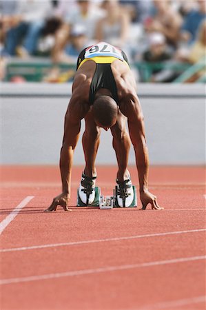 position start running men - Runner Preparing To Leave Starting Blocks Stock Photo - Premium Royalty-Free, Code: 622-05602909