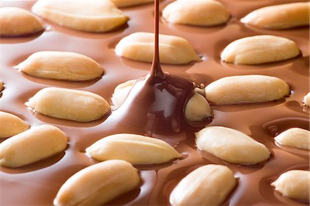 Chocolate Dropping On Peanuts Stock Photo - Premium Royalty-Free, Code: 622-06010047
