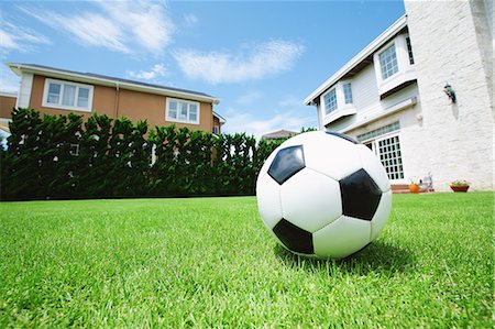 simsearch:6116-07236128,k - Soccer Ball On Grass With Buildings In Behind Foto de stock - Sin royalties Premium, Código: 622-06163944