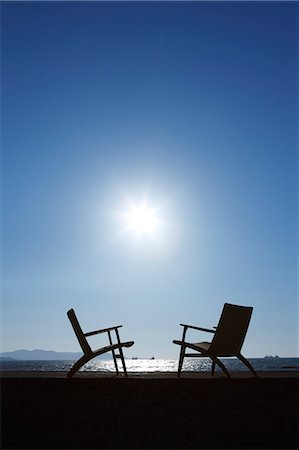 Two Deckchairs On Shore, Sun Shining On Sky Stock Photo - Premium Royalty-Free, Code: 622-06190716