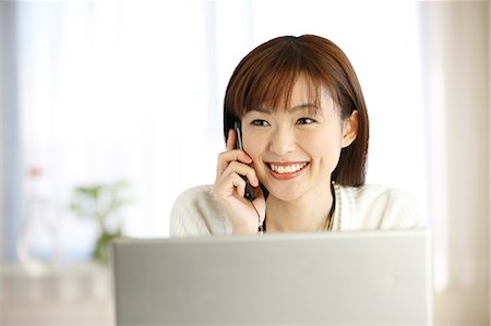 female executive - Smiling Japanese Woman Talking On Cellular Phone Foto de stock - Sin royalties Premium, Código: 622-06190771