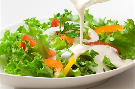 food salad - Pouring dressing on a vegetable salad Stock Photo - Premium Royalty-Free, Code: 622-06369907