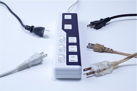Power strip and various cords on a white desk Stock Photo - Premium Royalty-Free, Code: 622-06397974
