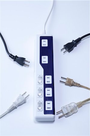 Power strip and various cords on a white desk Stock Photo - Premium Royalty-Free, Code: 622-06397973