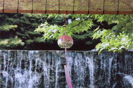 Wind chime and green maple leaves with waterfall in the background Stock Photo - Premium Royalty-Free, Code: 622-06398359