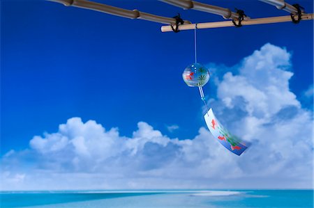 Wind chime and blue sky with clouds in the background Stock Photo - Premium Royalty-Free, Code: 622-06398364