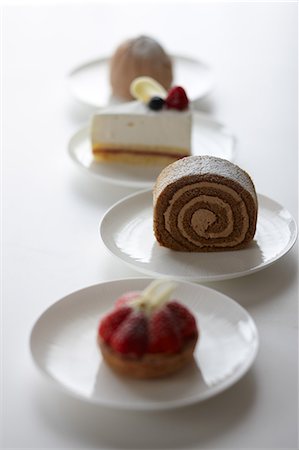 simsearch:622-06548665,k - Mixed cakes in a row on a table Fotografie stock - Premium Royalty-Free, Codice: 622-06548663