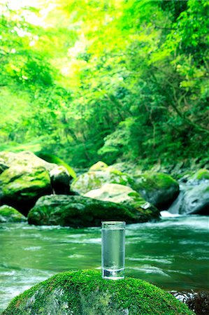 Glass of water near a mountain stream Foto de stock - Royalty Free Premium, Número: 622-06549341