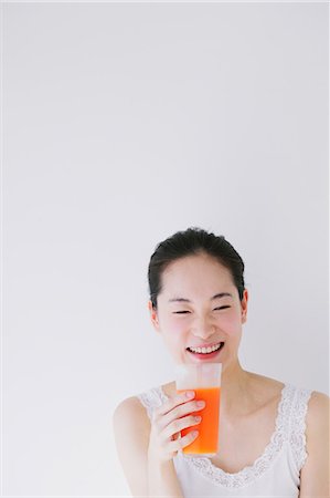 Young woman with vegetable juice smiling Stock Photo - Premium Royalty-Free, Code: 622-06964261